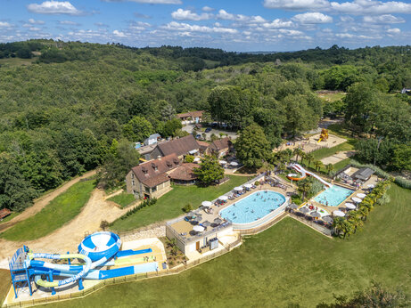 Luchtfoto van waterpark met zwembaden, glijbanen en speeltuin op camping CLICOCHIC Linotte in Le Bugue (24).