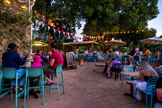 Levendig restaurant- en barterras 's avonds op camping CLICOCHIC Linotte in Le Bugue.
