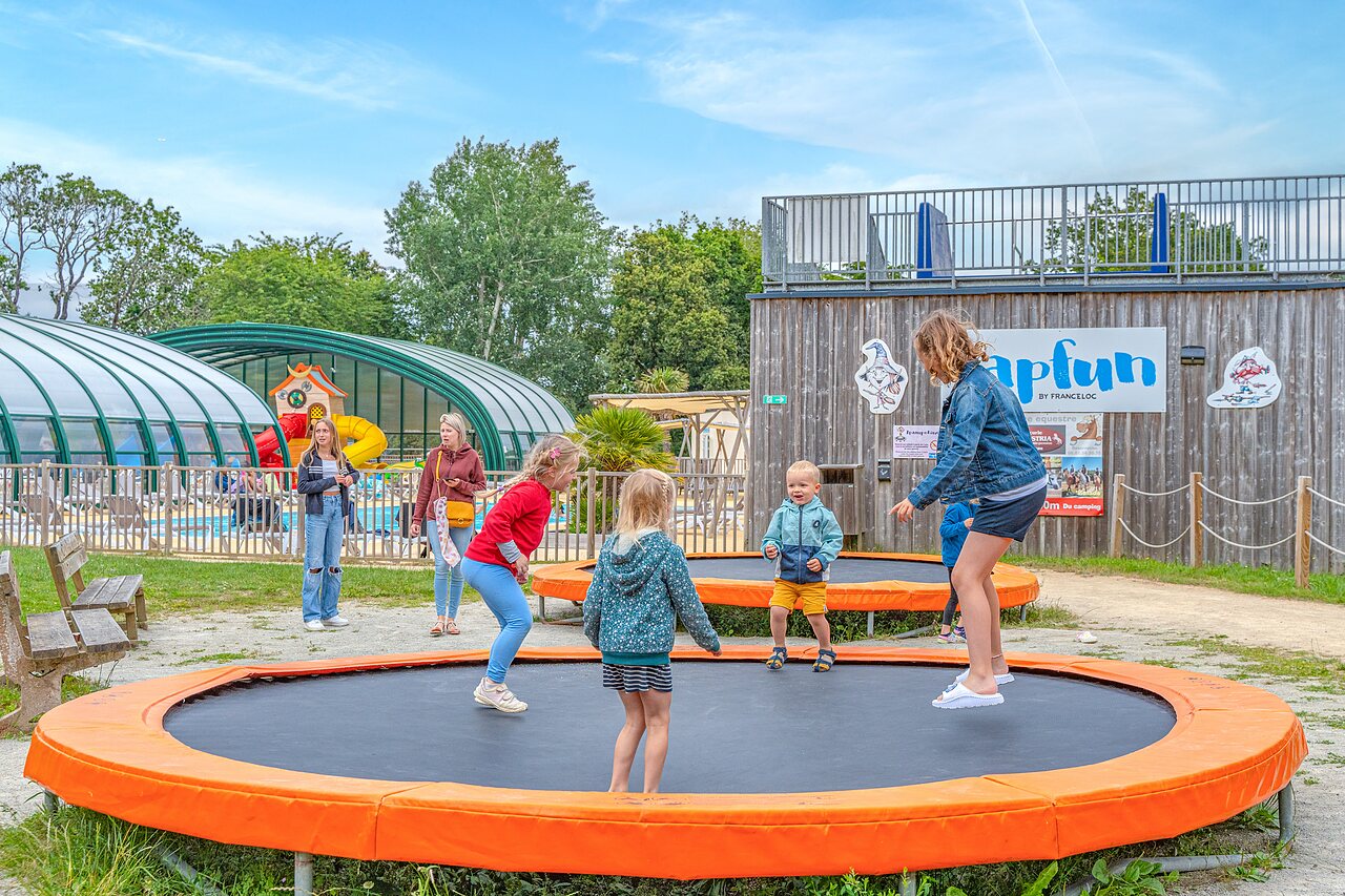 Kinderen op trampolines, overdekt zwembad op camping CAPFUN Lodge in SARZEAU (56).
