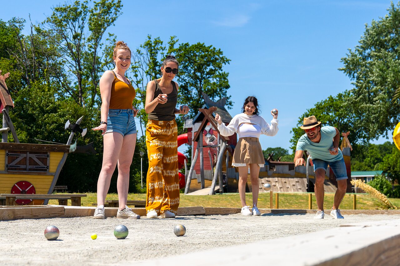 Vrienden spelen jeu de boules op zonnige baan, camping CAPFUN Lodge in SARZEAU (56).