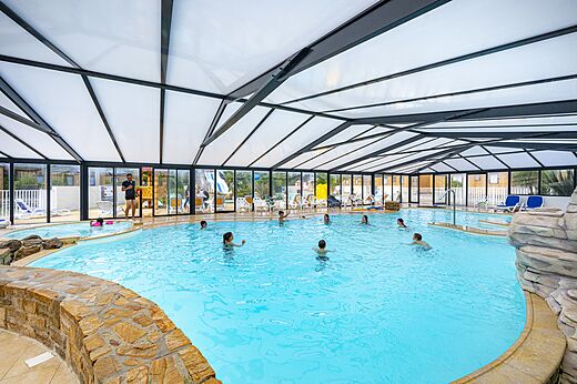 Overdekt zwembad met jacuzzi en zwemmers op camping CLICOCHIC Longchamp in Saint Lunaire (35).