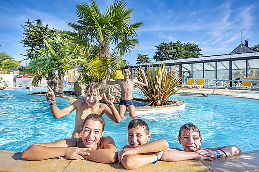 Lachende kinderen en tieners in het buitenzwembad op camping CLICOCHIC Longchamp in Saint Lunaire (35).