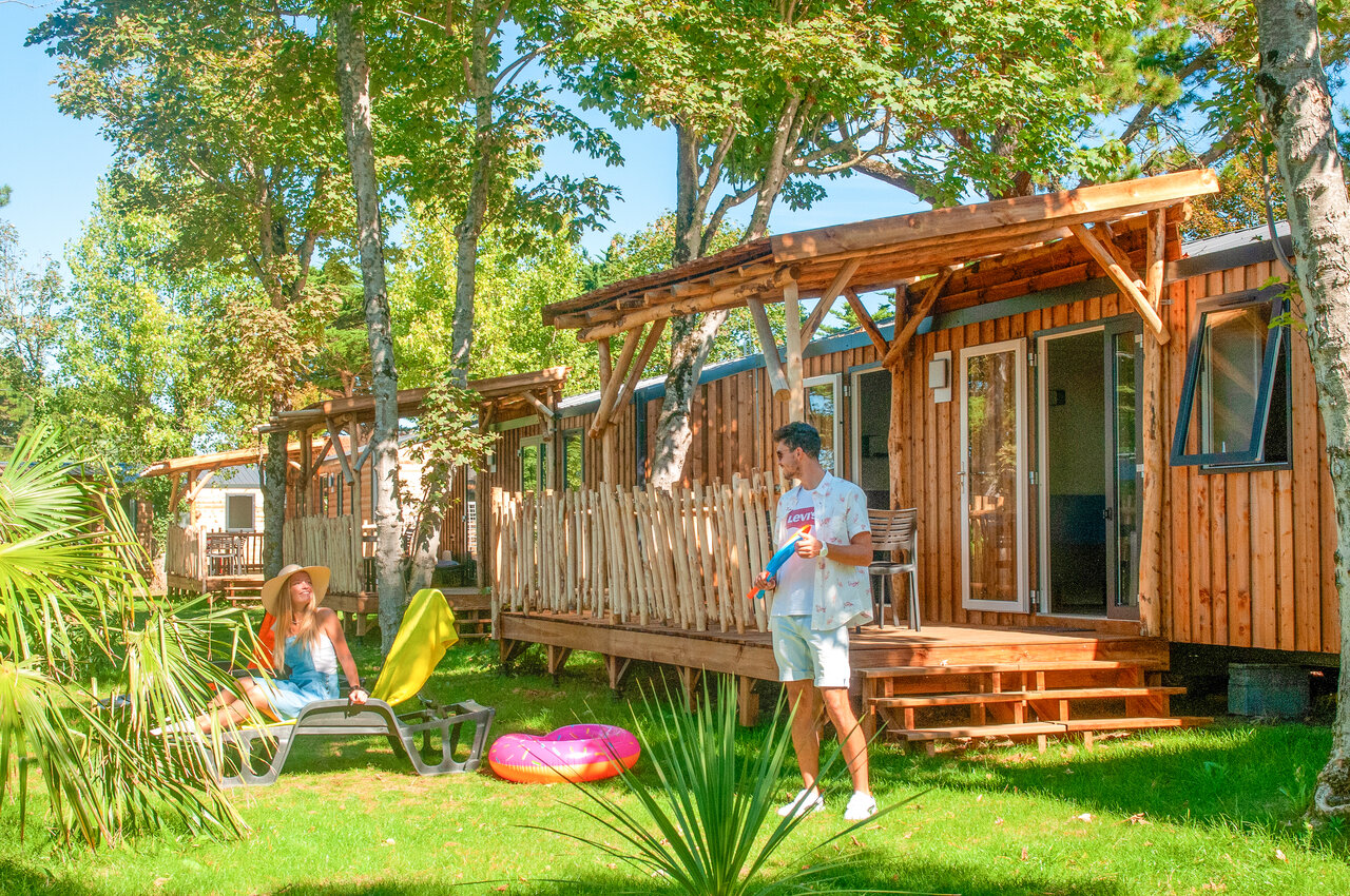 Houten stacaravans met terras, stel ontspant op camping CAPFUN Loubine in Les Sables d'Olonne (85).