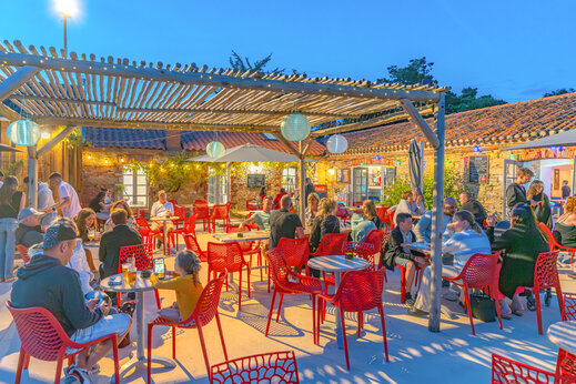 Druk buitenterras van restaurant met gasten op camping CAPFUN Loubine in Les Sables d'Olonne (85).