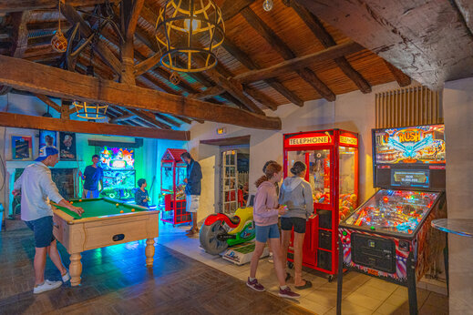 Speelzaal met biljart en arcadekasten op camping CAPFUN Loubine.