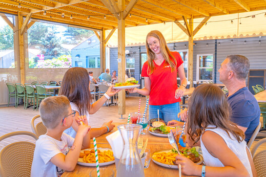 CAPFUN serveerster serveert maaltijden aan familie in het restaurant van camping CAPFUN Loubine in Les Sables d'Olonne (85).