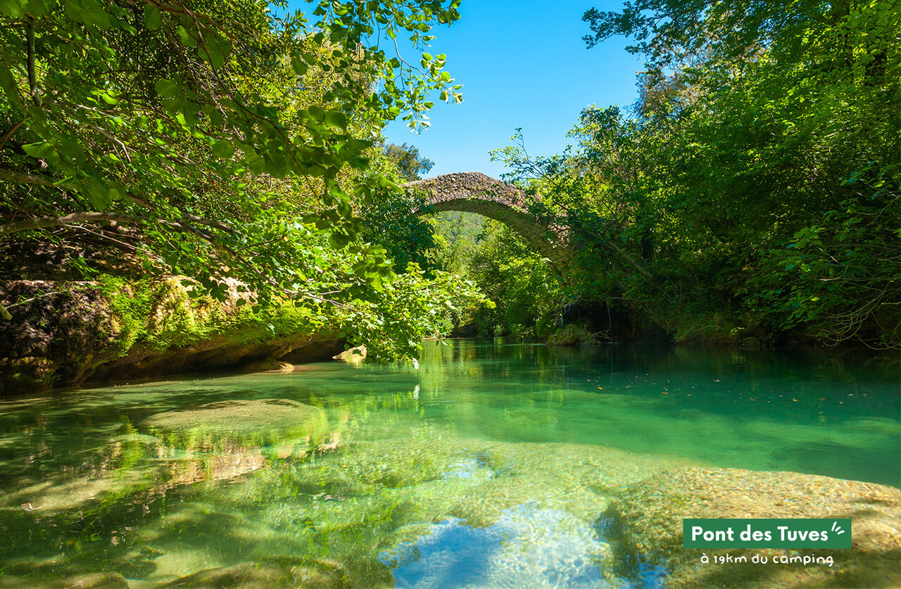 Pont des Tuves, turquoise rivier, historische stenen brug, weelderige natuur.