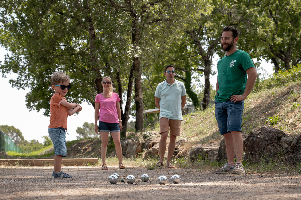 Familie speelt jeu de boules op een schaduwrijk terrein op camping CLICOCHIC Lou Cantaire in FAYENCE (83).