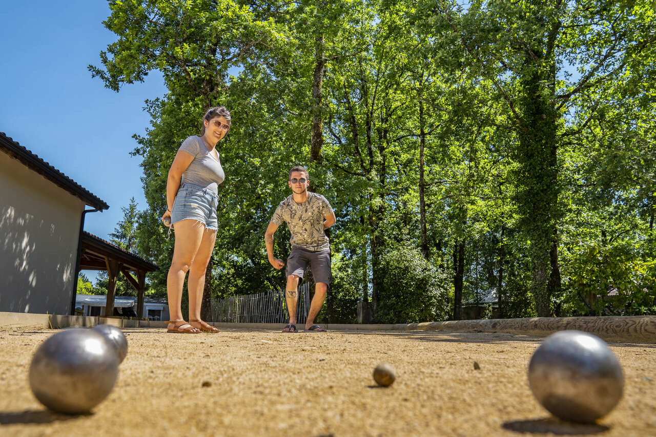 Levendig potje jeu de boules op het terrein van camping CLICOCHIC Lou Castel in Castelnaud-la-Chapelle.