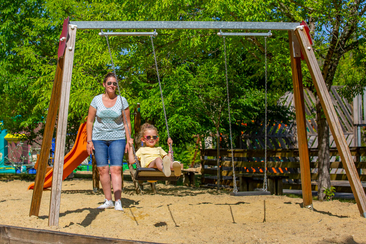 Kind op schommel, speeltuin op camping CLICOCHIC Lou Castel in Castelnaud-la-Chapelle (24).