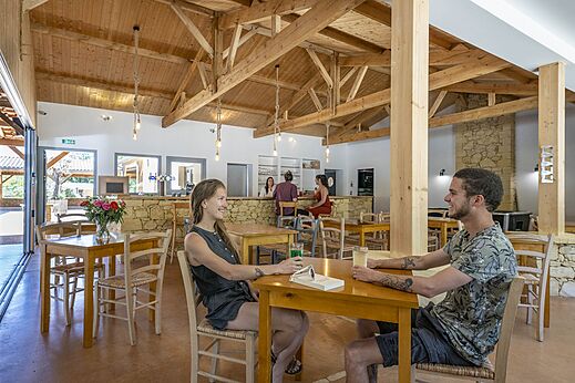 Gezellige bar en restaurantruimte met gasten op camping CLICOCHIC Lou Castel.
