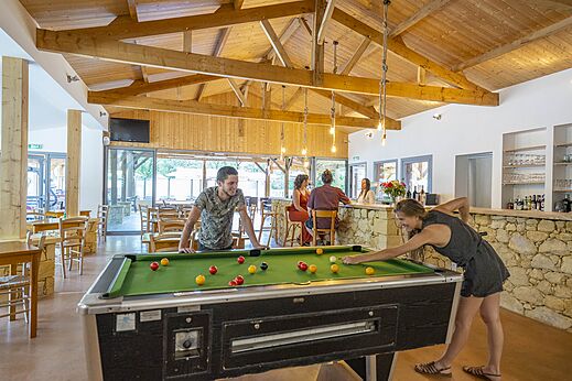 Biljartspel en levendige bar op camping CLICOCHIC Lou Castel in Castelnaud-la-Chapelle (24).