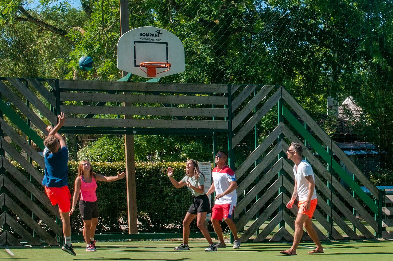 Familie speelt basketbal op multisportveld op camping CAPFUN Lou Puntaou in LEON (40).