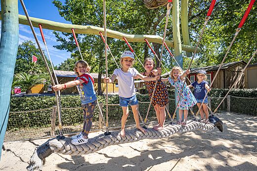 Lachende kinderen spelen op speeltoestel op camping CAPFUN Lou Puntaou in LEON (40).