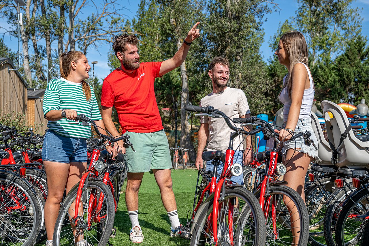 Vrienden kiezen rode fietsen op camping CAPFUN Lou Village in Vendres (34).