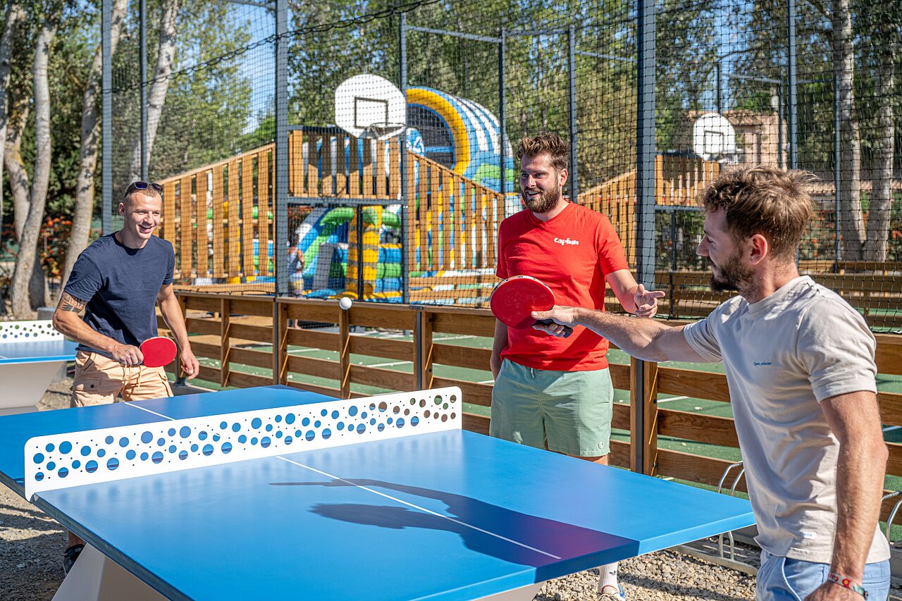 Tafeltenniswedstrijd met vrienden, multisportterrein op camping CAPFUN Lou Village in Vendres (34).