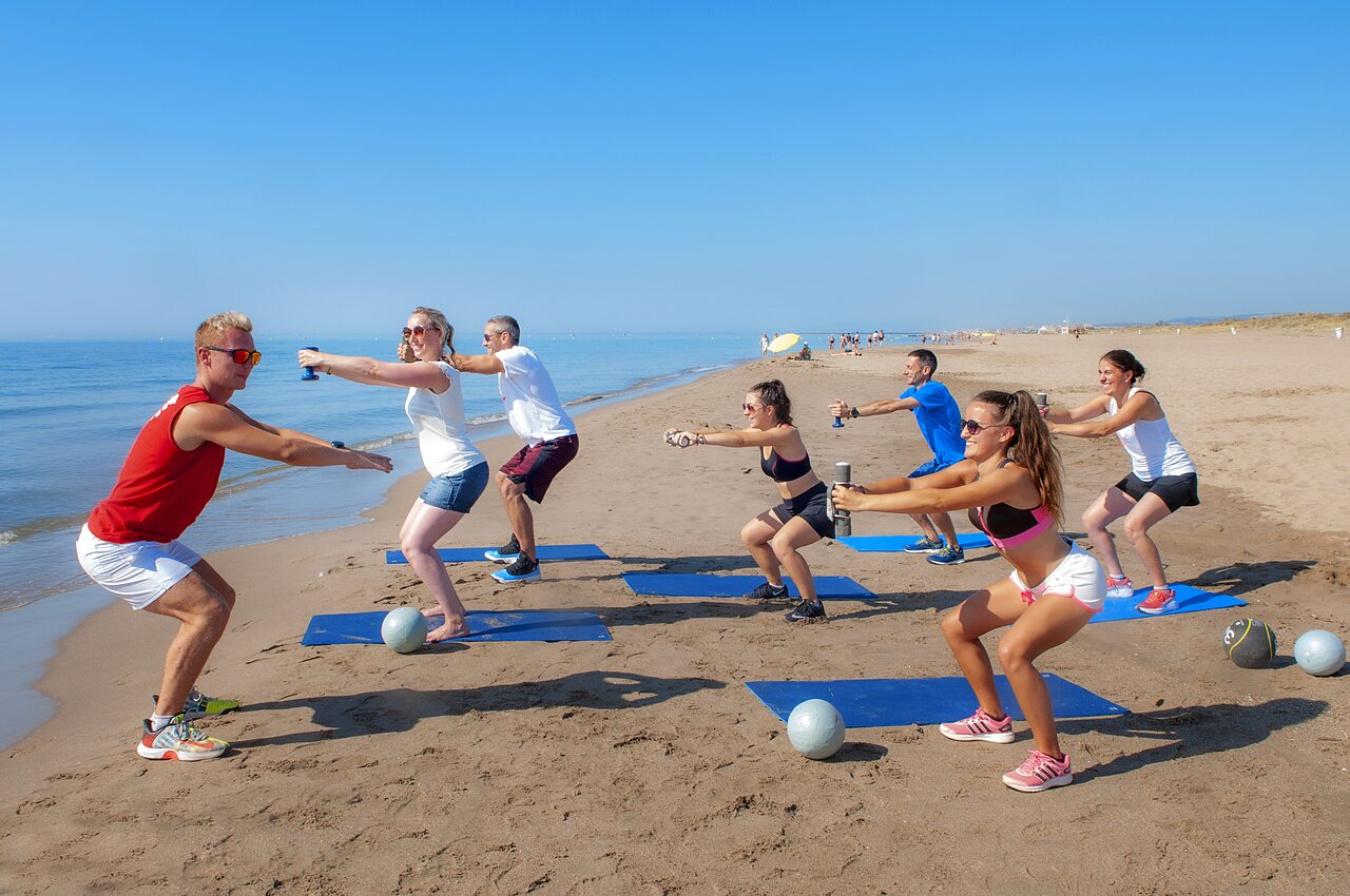 Fitnesssessie op het strand met animator op camping CAPFUN Lou Village in Vendres (34).