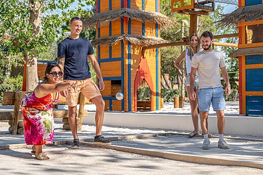 Familie speelt jeu de boules op speelterrein bij camping CAPFUN Lou Village in Vendres (34).