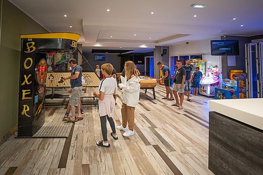 Speelzaal met boksautomaat, tafelvoetbal en arcades op camping CAPFUN Lou Village in Vendres (34).