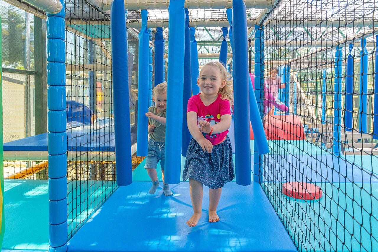 Lachende kinderen spelen in overdekte speelstructuur op camping CAPFUN Madrague in PORNIC (44).