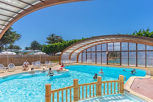 Buiten- en overdekt zwembad met zwemmers op camping CAPFUN Madrague in PORNIC (44).
