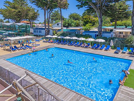 Buitenzwembad, zwemmers, stoelen en parasols op camping CAPFUN Madrague in PORNIC (44).