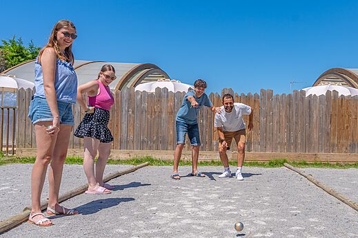 Familie speelt jeu de boules op zonnig terrein op camping CAPFUN Madrague in PORNIC (44).