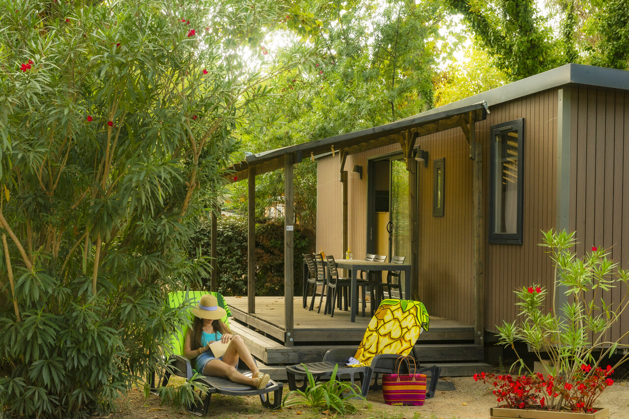 Moderne stacaravan met terras en vrouw ontspannend op CAPFUN Mael, ARGELES SUR MER (66).