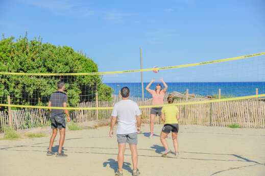 Zandvolleybalveld met spelers en zee op de achtergrond op camping CAPFUN Marina d'Aléria in Aleria (20).