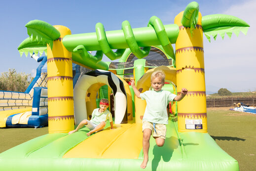 Kinderen spelen op een gigantisch opblaasbaar speeltoestel op camping CAPFUN Marina d'Aléria in Aleria (20).