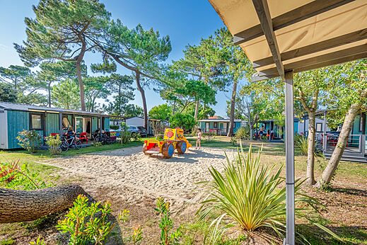 Stacaravans en speeltuin met tractor op camping VAGUES OCEANES Marina Landes.