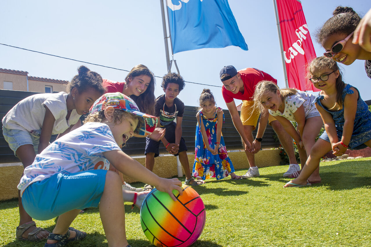 Vrolijke kinderanimatie met animatoren en bal op camping VAGUES OCEANES Marinette.