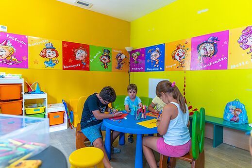Kinderen tekenen en spelen in de speelzaal op camping VAGUES OCEANES Marinette in Ste Marie La Mer (66).