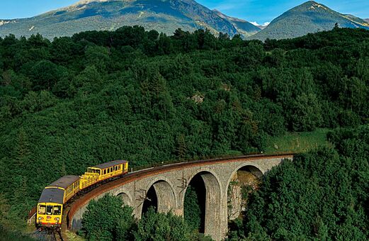 Gele trein over stenen viaduct in de Pyrenee�n, bezienswaardigheid.