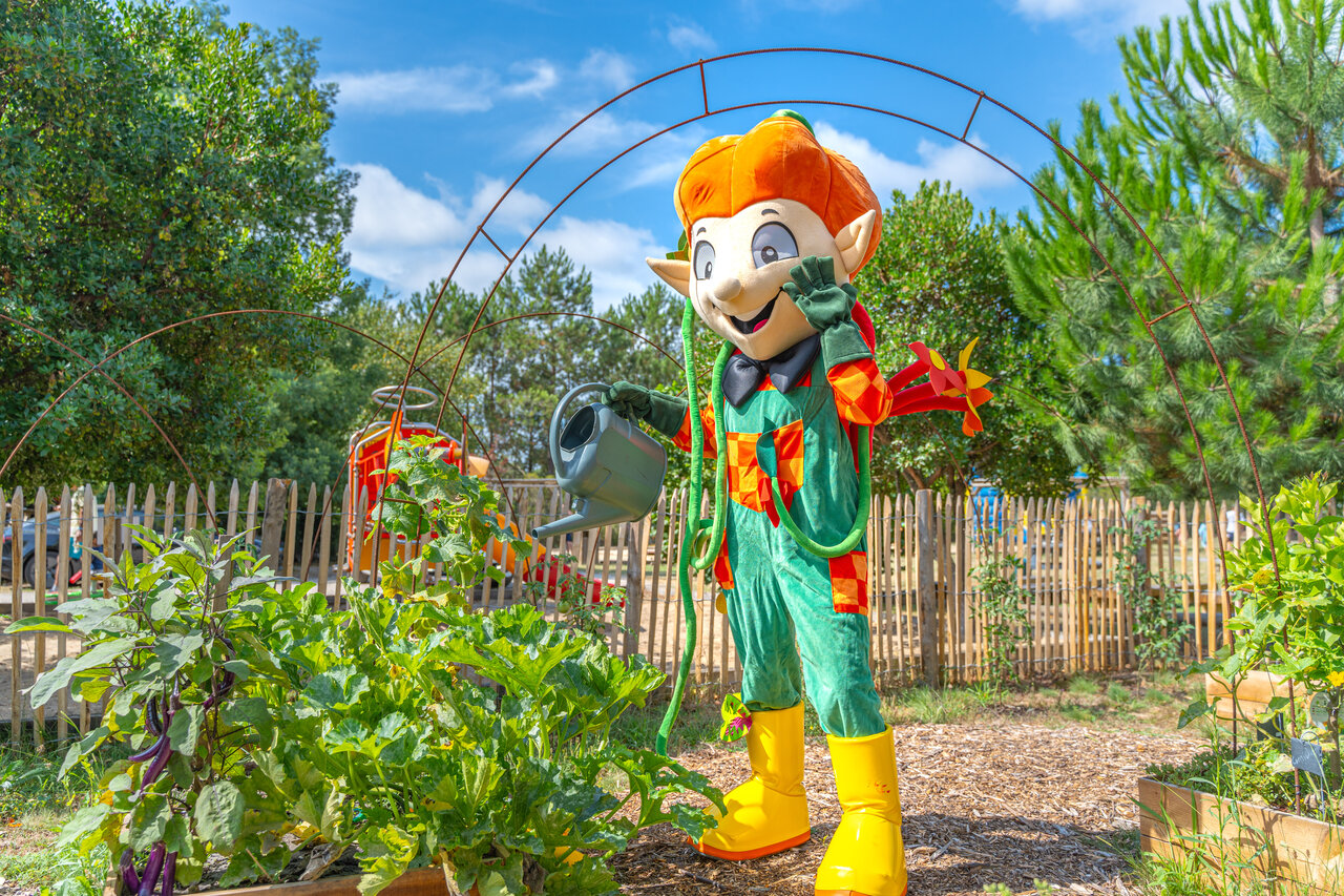 Tuinier mascotte besproeit planten in de moestuin op camping CLICOCHIC M�doc Bleu in Carcans (33).