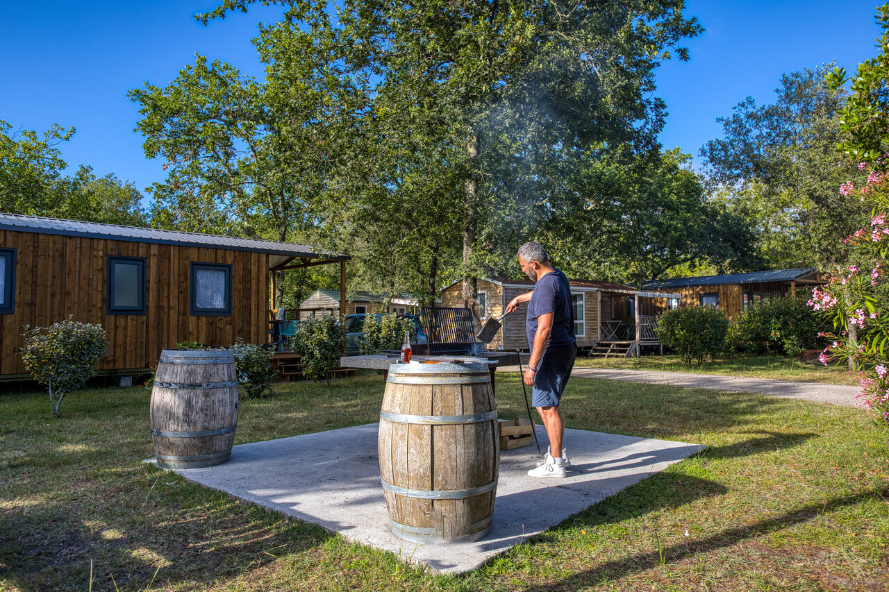 Man barbecuet voor Mobil-homes op camping CLICOCHIC M�doc Bleu in Carcans (33).