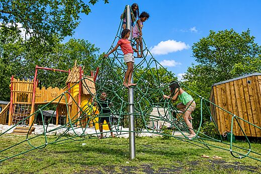 Kinderen spelen op klimnetstructuur op camping CLICOCHIC M�doc Bleu.