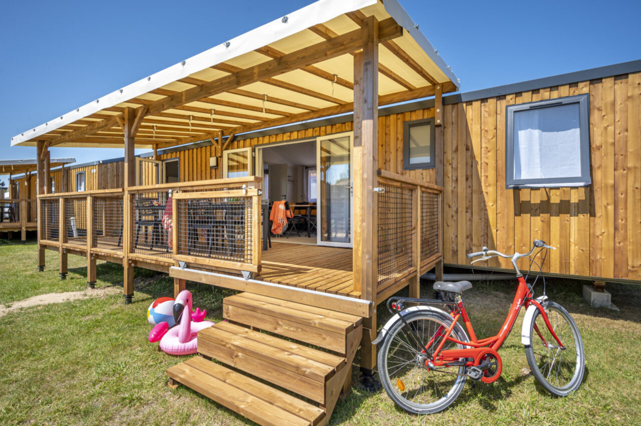Houten Mobil-home met terras, rode fiets op camping CAPFUN Mer in Labenne-Oc�an (40).