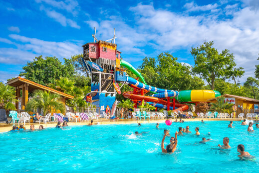 Buitenzwembad en waterglijbanen met stoelen op camping CAPFUN Mer in Labenne-Oc�an (40).