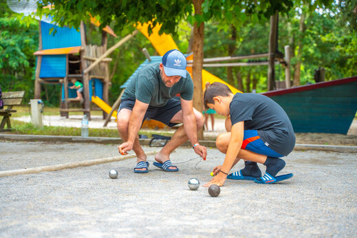 Vader en zoon spelen jeu de boules op camping CAPFUN Mer in Labenne-Océan.