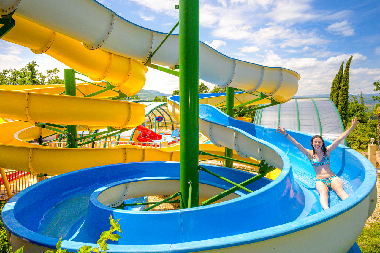 Jonge vrouw op waterglijbaan, waterpark CAPFUN Merle Roux, Baix (07).