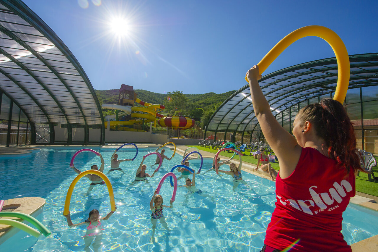 Overdekt zwembad, glijbanen en aqua gym op camping CAPFUN Merle Roux in Baix.