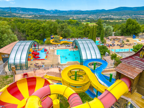 Kleurrijke waterglijbanen en buitenzwembaden op camping CAPFUN Merle Roux in Baix (07).