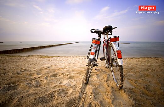Twee fietsen op een fijn zandstrand bij de zee op camping CAPFUN Mer et Soleil in Cap d'Agde (34).
