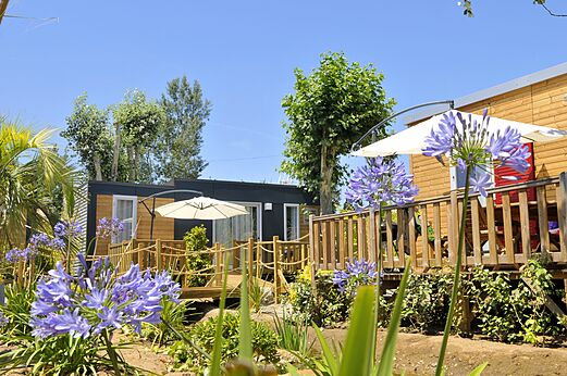 Moderne Mobil-homes met houten terras en parasols op camping CAPFUN Mer et Soleil in Cap d'Agde (34).