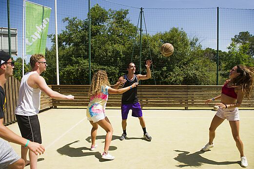 Jongeren basketballen op een multisportterrein op camping CAPFUN Mer et Soleil in Cap d'Agde (34).