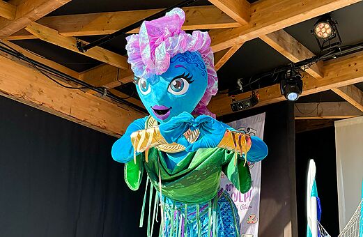 Mascotte blauw en groen maakt hart, camping VAGUES OCEANES Michelière Givrand (85).