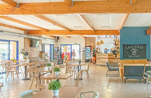 Moderne bar- en restaurantruimte met tafels en stoelen op camping VAGUES OCEANES Michelière in Givrand (85).