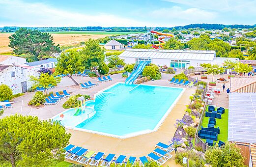 Groot buitenzwembad met glijbaan en stoelen op camping VAGUES OCEANES Micheli�re in Givrand (85).