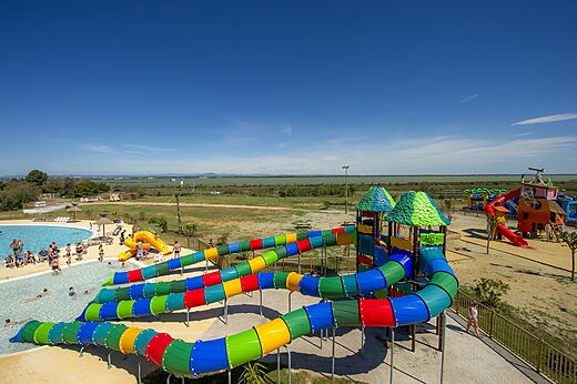 Kleurrijke waterglijbanen en buitenzwembad op camping CAPFUN Mille Pépites in Carnon (34).